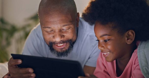 Ojciec, dziecko i tablet w sypialni w nocy oglądając kreskówki i w łóżku z technologią i śmiechem. Szczęśliwy, korzystających i online dla filmów, cyfrowy i internet w domu strumieniowe lub więzi razem. - Zdjęcie, obraz