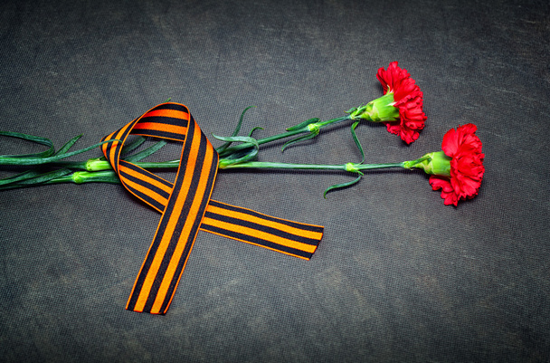 Carnations and St. George ribbon on a dark background. May 9 Victory Day - Photo, Image