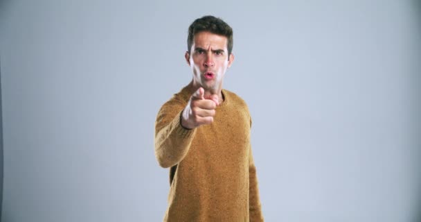 Threat, challenge and hand gesture of a man in studio on a gray background for fighting or conflict. Portrait, pointing or come here and an angry young person warning you with violence or frustration. - Footage, Video