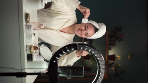Mulher bonita removendo maquiagem com almofadas de algodão branco, gravando vlog na câmera do smartphone para o canal de mídia social. Espaço de cópia - Filmagem, Vídeo
