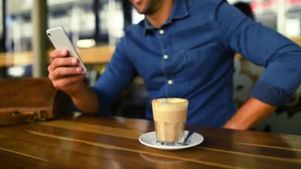 Kezek, telefon és kávé egy személlyel a kávézó közelkép asztalnál a közösségi média vagy a kommunikáció. Mobil, kapcsolat vagy hálózatépítés és egy ügyfél egy étteremben egy koffein ital, hogy pihenjen. - Felvétel, videó