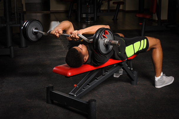 Young man doing arms bench french press workout in gym - Photo, Image