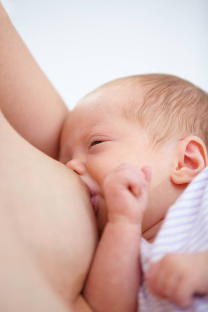 Close-up, vrouw en baby voor borstvoeding in huis voor honger, voedsel en welzijn in de gezondheid. Liefde, verbondenheid en relatie in moederschap met voeding in kinderopvang voor groei, ontwikkeling en toekomst. - Foto, afbeelding