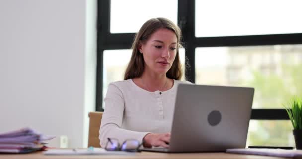 Mujer de negocios enfocada que trabaja en la computadora portátil en la oficina en casa. Gerente femenina escribiendo en el teclado del ordenador portátil en interiores - Imágenes, Vídeo