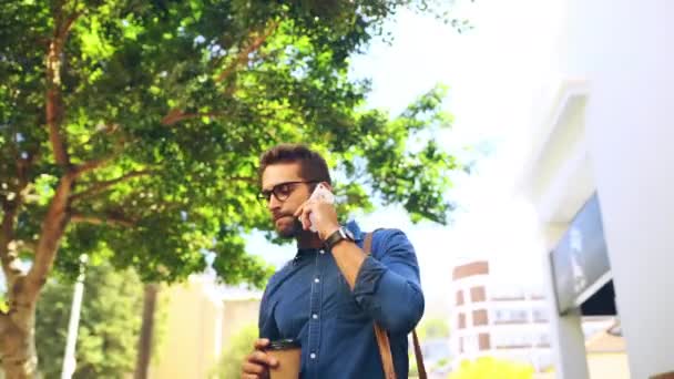 Man, happy and coffee with phone call outdoor for networking, conversation or talking in nature. Businessman, person or beverage and smartphone or bag in street for communication and laughing in city. - Footage, Video