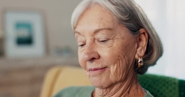 Seniorin, Gesicht Nahaufnahme und Erinnerung in einem Altenheim mit fröhlichem Denken und Nostalgie. Ältere Frau, entspannen Sie sich und lächeln Sie in einem Wohnzimmer auf einem Sofa mit Dankbarkeit auf einer Lounge-Couch. - Filmmaterial, Video