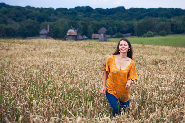 Όμορφη νεαρή γυναίκα σε ένα χωράφι με σιτάρι, Ουκρανία - Φωτογραφία, εικόνα