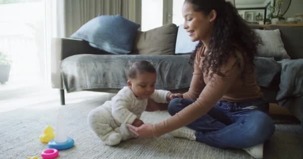 .Äiti, vauva ja leikkiminen yhdessä kotona sitoutumista, oppimista ja laatuaikaa varten. Nuori nainen, jolla on lapsi rakkautta, hoitoa ja tukea kasvua ja kehitystä varten lattialla perheen oleskelutilassa - Materiaali, video