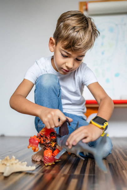 Beyaz çocuk evde oyuncaklarla oynuyor ve yaratıcılığını geliştiriyor. - Fotoğraf, Görsel