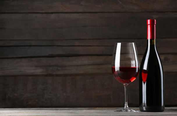 láhev vína se sklem na dřevěné pozadí - Fotografie, Obrázek