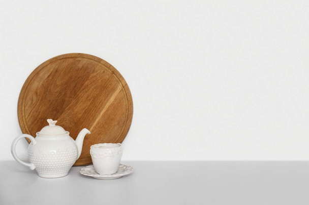 konvice, šálek a květináč na bílém kuchyňském pultu - Fotografie, Obrázek