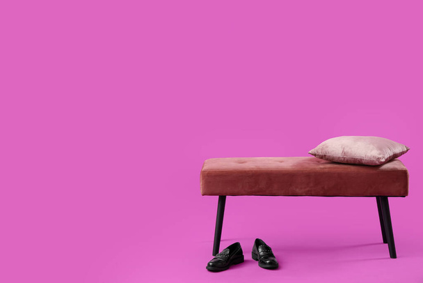 Скамейка с подушкой и туфлями на розовом фоне - Фото, изображение