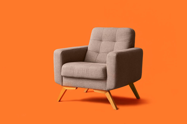 Сучасне сіре крісло на помаранчевому фоні - Фото, зображення