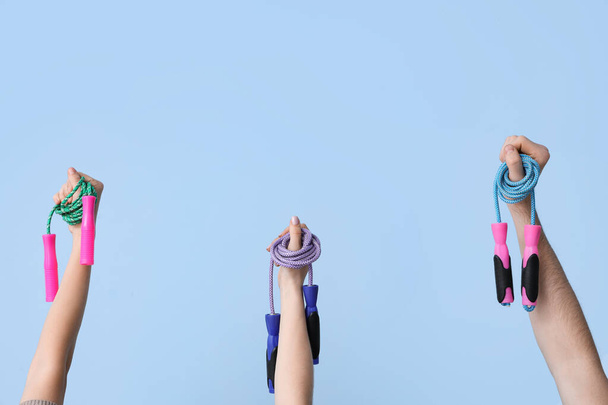 Женские руки с скакалками на синем фоне - Фото, изображение