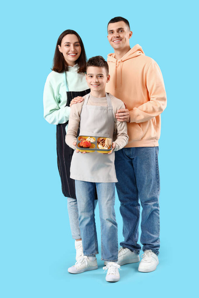 Little boy with lunchbox and his parents on blue background - Photo, Image