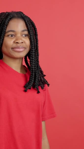 Szczęśliwa Afrykanka otrzymuje prezent od kogoś w studio z czerwonym tłem - Materiał filmowy, wideo