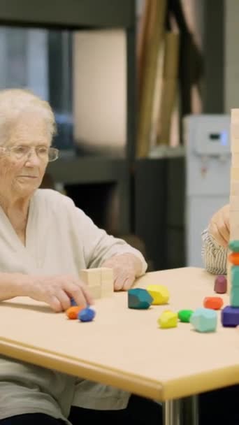 Vídeo de três pessoas idosas jogando jogos de tabuleiro de habilidade em um lar de idosos - Filmagem, Vídeo