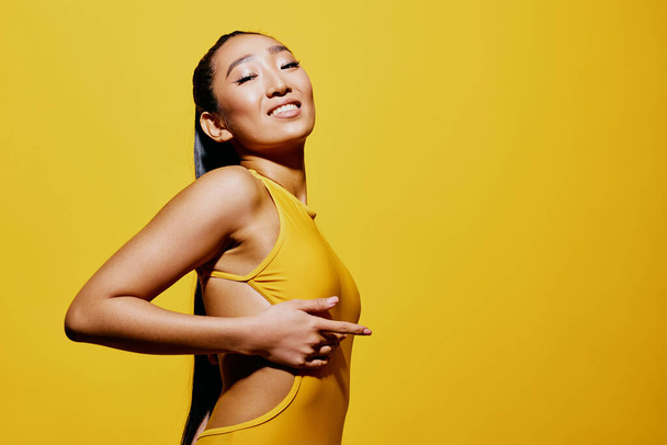 Yllättynyt nainen henkilö trendikäs yksi hauska tyyli uimapuku söpö elämäntapa hiukset melko iloinen muoti hymy aasialainen kesä keltainen tyylikäs muotokuva meikki ilme kauneus kasvot - Valokuva, kuva