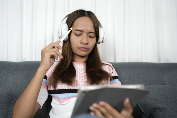 Азиатка слушает музыку на iPad, чтобы уменьшить стресс на работе - Фото, изображение