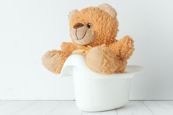 un orsacchiotto in un vasino accanto a una pila di pannolini
 - Foto, immagini