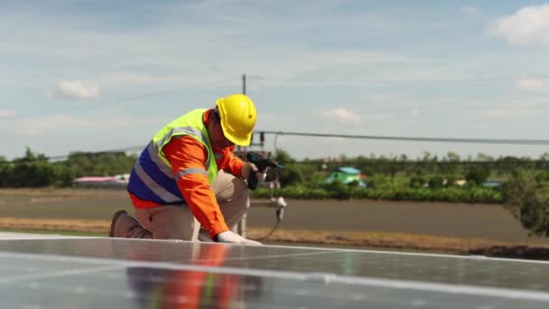 Mérnökök villanyszerelők technikus dolgozik a tetőtéri ipari üzem telepítése napelemek alternatív energia segítségével elektromos fúrók szilárdan rögzítő kábelpályák villamos energia. - Felvétel, videó