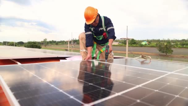 Mérnökök villanyszerelők technikus dolgozik a tetőtéri ipari üzem telepítése napelemek alternatív energia segítségével elektromos fúrók szilárdan rögzítő kábelpályák villamos energia - Felvétel, videó