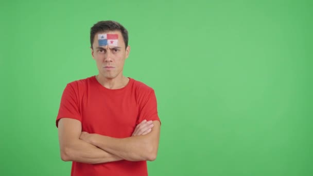 Βίντεο στο στούντιο με το χρώμα ενός αξιοπρεπούς και σοβαρού άνδρα με παναμά σημαία ζωγραφισμένη στο πρόσωπο κοιτάζοντας την κάμερα με αξιοπρέπεια - Πλάνα, βίντεο