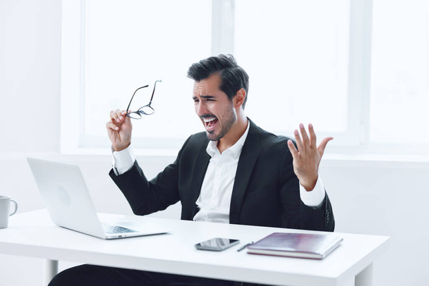 Férfi zavaros asztal szakmai internet gondolkodás dolgozó laptop íróasztal szemüveg személy üzleti fáradt fehér iroda jóképű menedzser ül hangsúlyozta végrehajtó - Fotó, kép