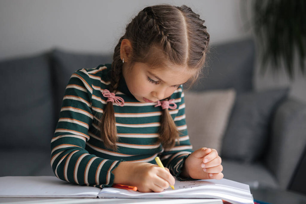 Detailní záběr rozkošné dívčí kresby. Kreativní holčička maluje doma. Kvalitní fotografie - Fotografie, Obrázek