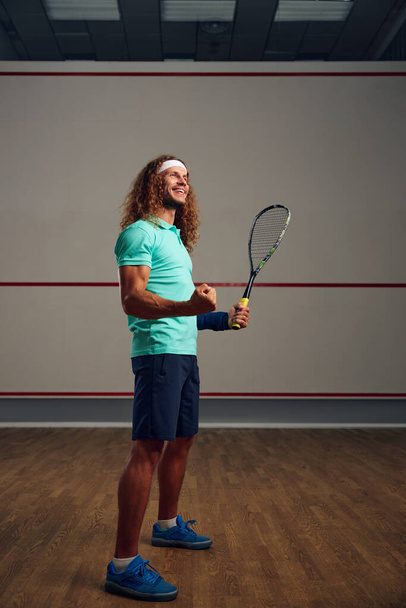 Portret zadowolonego squasha zaciskającego pięść radującego się zwycięstwem w grze lub udanym zakończeniem treningu - Zdjęcie, obraz