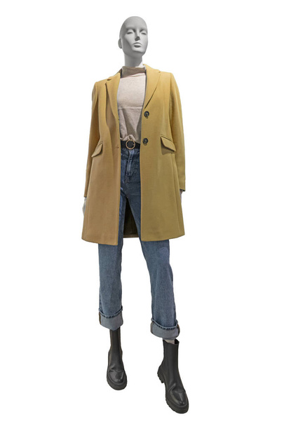 Full length female mannequin dressed in yellow wool coat and blue jeans, isolated on white background with clipping path. Female autumn outfit - Foto, Bild