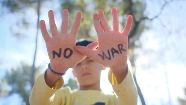jongen zonder oorlog woorden op handpalmen, close-up - Video