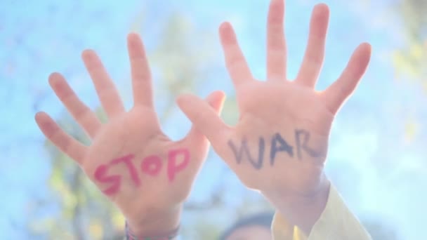 jongen met stop oorlog woorden op palmen, close-up - Video