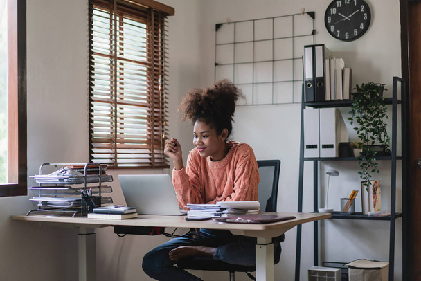Femme d'affaires afro-américaine lisant les données financières sur l'ordinateur portable et la stratégie de pensée des entreprises. - Photo, image
