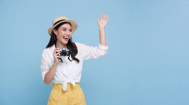 Szczęśliwy uśmiech Kobieta fotograf jest robienie zdjęć z aparatem dslr izolowane studio niebieskie tło. - Zdjęcie, obraz