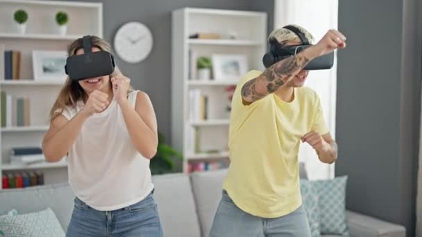 Hermosa pareja jugando boxeo videojuego usando gafas de realidad virtual celebrando en casa - Imágenes, Vídeo