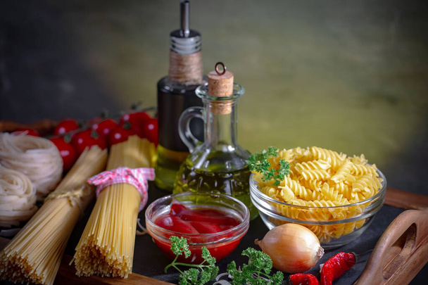 Rohe Pasta in Komposition mit Gemüse in der Küche. - Foto, Bild