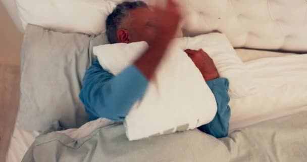 Sleep stress, senior and man with insomnia in bed at home with struggle and bad dream. House, top view and mature male person frustrated from fatigue and uncomfortable sleeping position with anxiety. - Footage, Video