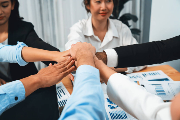 Wielorasowi biznesmeni tworzą synergiczny stos dłoni razem w sali konferencyjnej jako kooperacja lub budowanie zespołu dla pracowników korporacyjnych w miejscu pracy. Habiliment - Zdjęcie, obraz