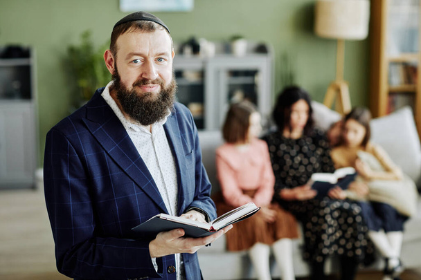 Талия портрет бородатого еврея, носящего кипу и смотрящего на камеру с книгой, копировальным пространством - Фото, изображение
