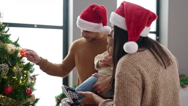 Pareja e hijo decorando árbol de Navidad en casa - Imágenes, Vídeo