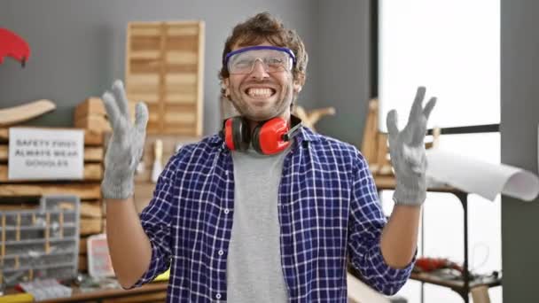 Χαρούμενος νεαρός ξυλουργός γιορτάζει την επιτυχία στο εργαστήριο ξυλουργικής, ουρλιάζοντας νίκη με αυτοπεποίθηση χαμόγελο, χαρούμενη έκφραση ανυψώνει τη νίκη του - Πλάνα, βίντεο