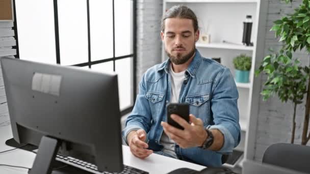 若いヒスパニック系男性ビジネスワーカーがオフィスで笑顔でスマートフォンでセルフィーを作る - 映像、動画