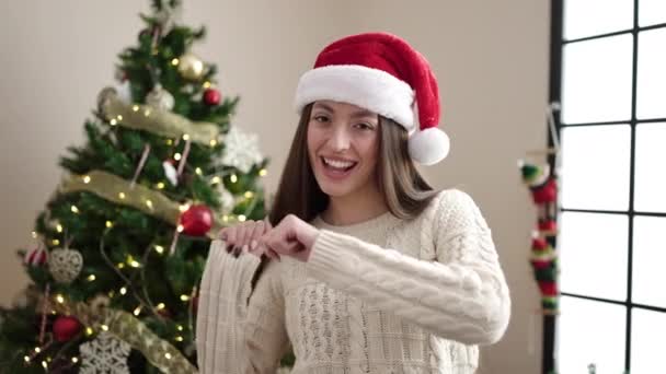 Νεαρή όμορφη Ισπανίδα που στέκεται δίπλα στο χριστουγεννιάτικο δέντρο χορεύοντας στο σπίτι - Πλάνα, βίντεο