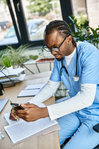 verward Afrikaans-Amerikaanse arts met bril het nemen van notities en consultancy per telefoon, telegezondheid - Foto, afbeelding