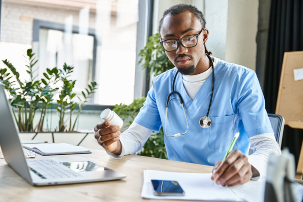 töprengő jóképű afro-amerikai orvos sztetoszkóppal jegyzetel és tablettákat tart a kezében - Fotó, kép