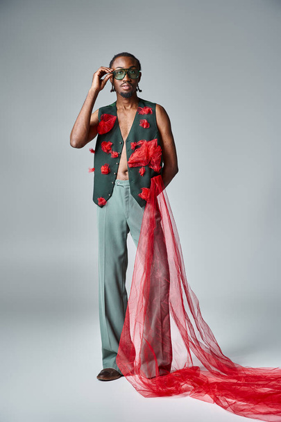 stylový africký Američan se slunečními brýlemi v pulzujícím oděvu při pohledu do kamery, módní koncept - Fotografie, Obrázek