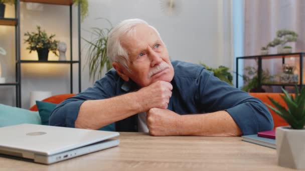 Portrait of sad stressed senior grandfather man sitting at home looks pensive thinks over life concerns, suffers from unfair situation. Problem crisis depression feeling bad sick ill annoyed burnout - Footage, Video