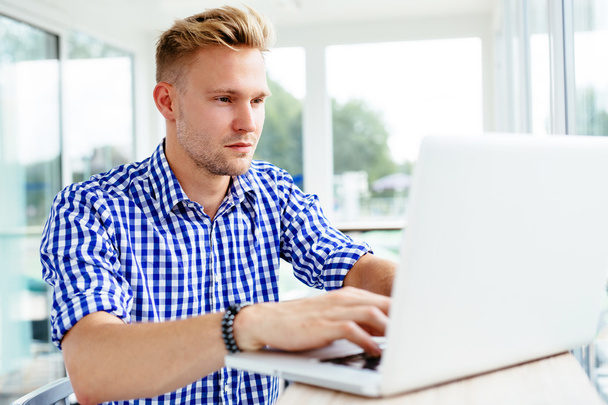 Man browsing internet on a laptop - Fotó, kép