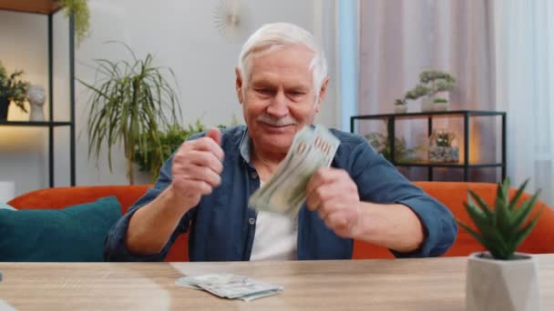 Pianificazione bilancio familiare. Buon uomo anziano contando denaro contante calcolare bollette domestiche a casa. Vecchio nonno anziano soddisfatto della pensione di stipendio di reddito e risparmia soldi per i regali di vacanza pianificati - Filmati, video